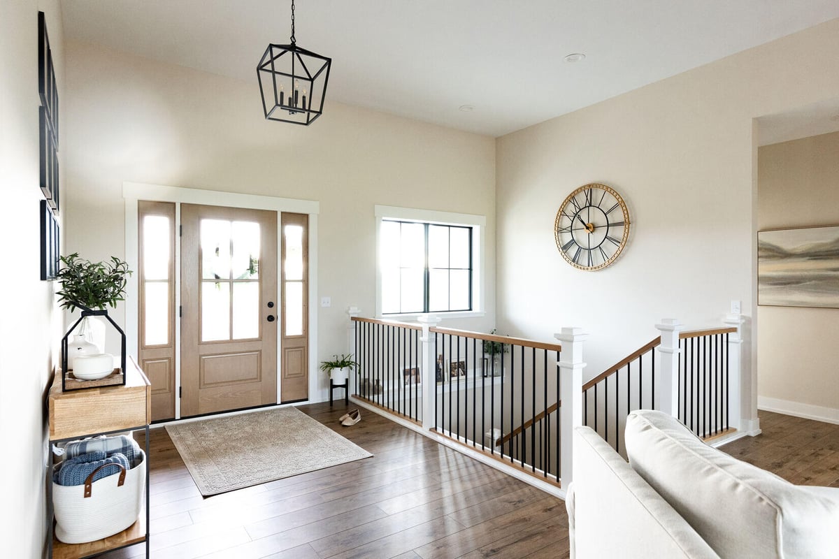 Entryway with wood double doors and staircase railing in West Michigan main floor remodel by Ridgewood Home Construction
