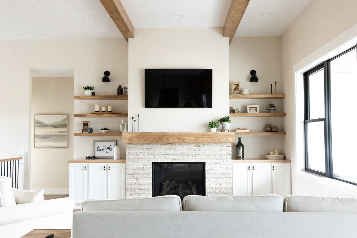 Modern living room fireplace wall with built-in shelving in a West Michigan main floor remodel by Ridgewood Home Construction