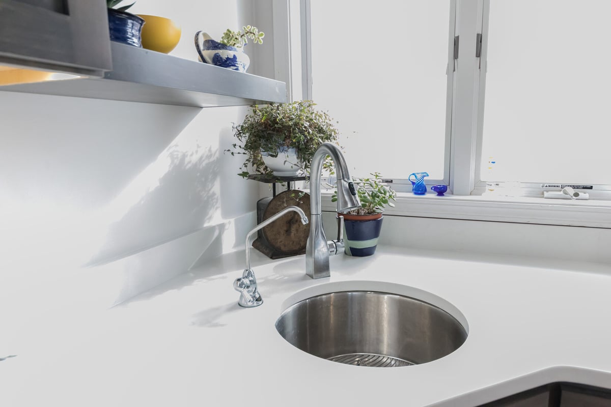 Kitchen sink with potted plants by a sunny window in Cascade, MI remodel by Ridgewood Home Construction