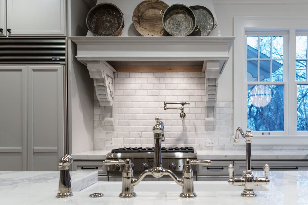 Custom kitchen remodel by Ridgewood Home Construction in East Grand Rapids featuring chrome fixtures and white subway tile backsplash