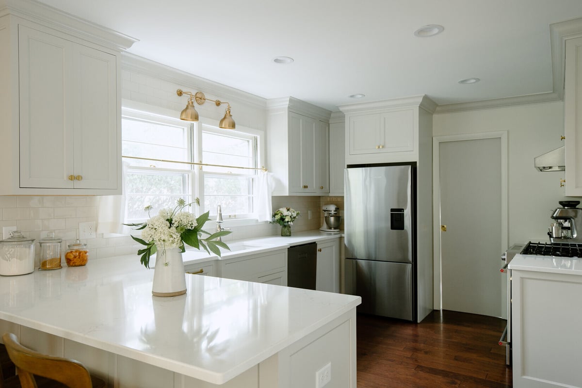 Bright kitchen remodel in East Grand Rapids by Ridgewood Home Construction with white cabinetry and brass fixtures