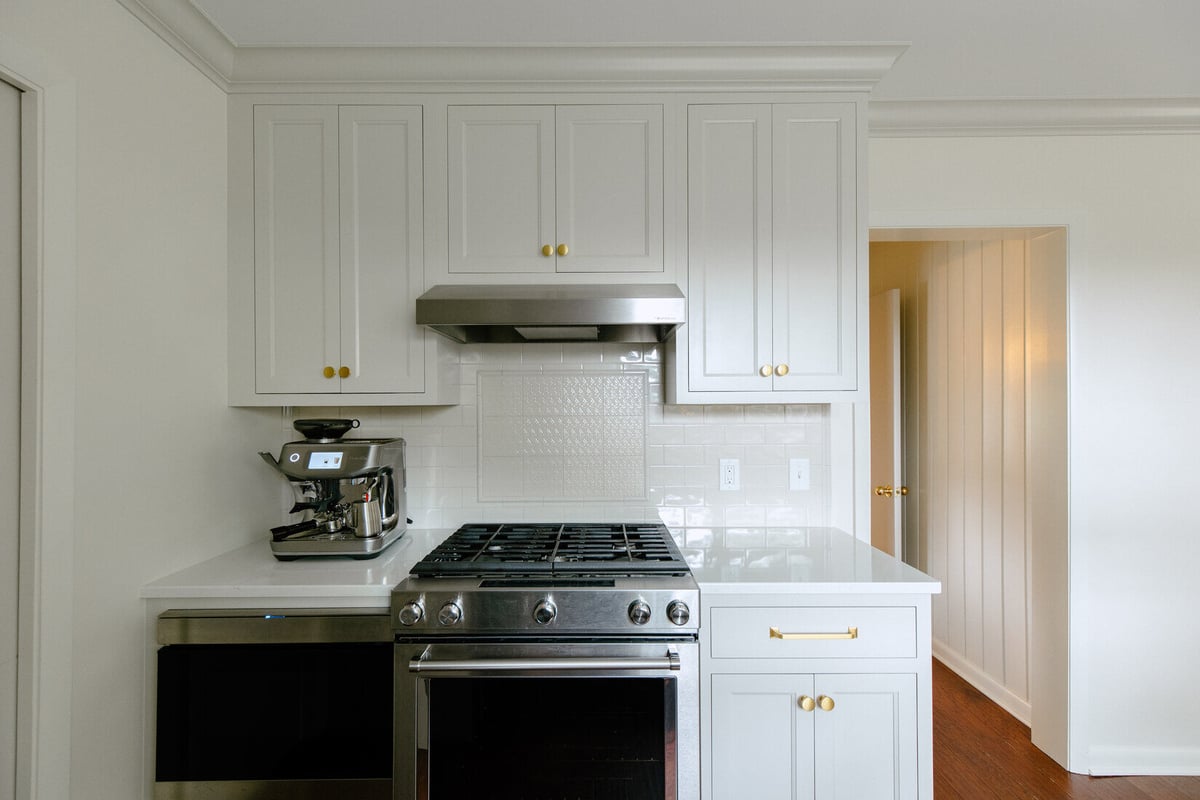 Kitchen stove wall with espresso machine and range hood in East Grand Rapids remodel by Ridgewood Home Construction