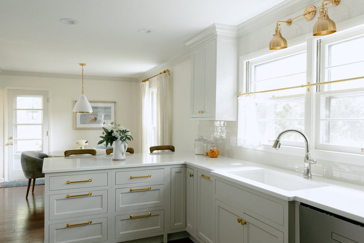 Light-filled kitchen remodel with island seating and gold accents by Ridgewood Home Construction in East Grand Rapids