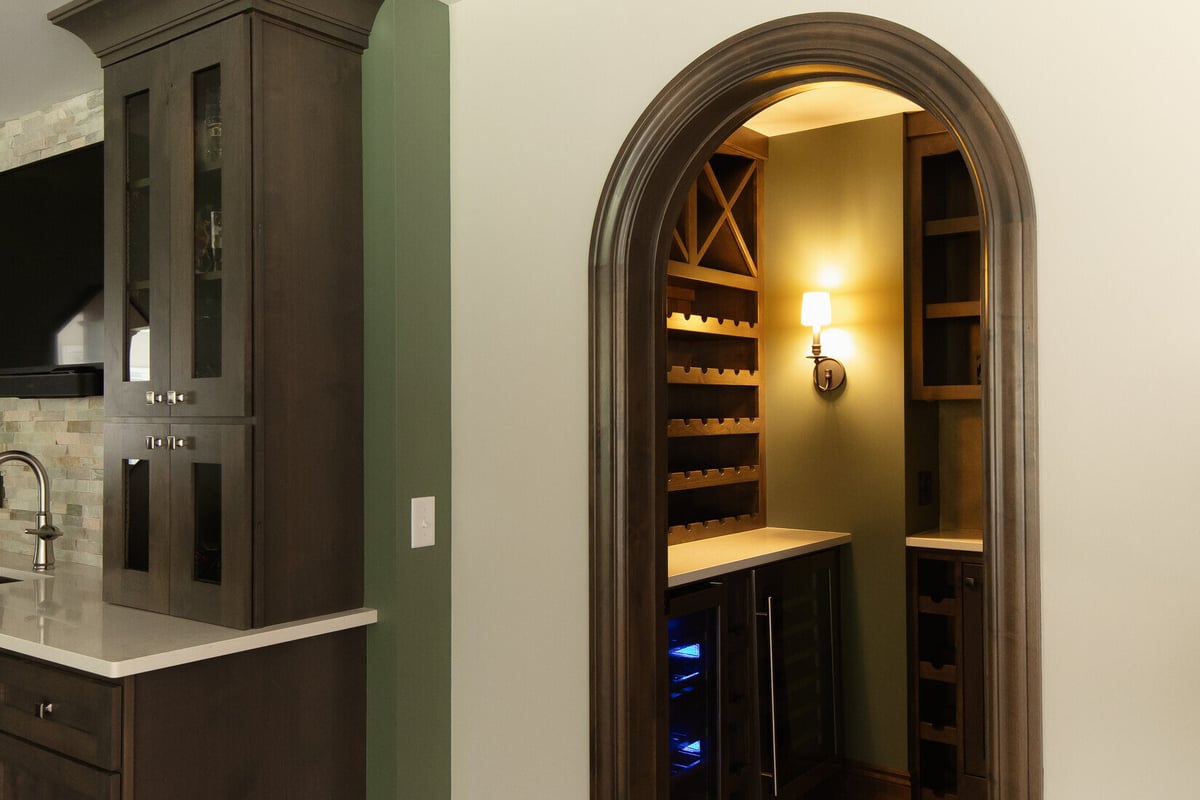 Arched doorway leading to wine storage area in custom basement remodel by Ridgewood Home Construction in Grand Rapids Township