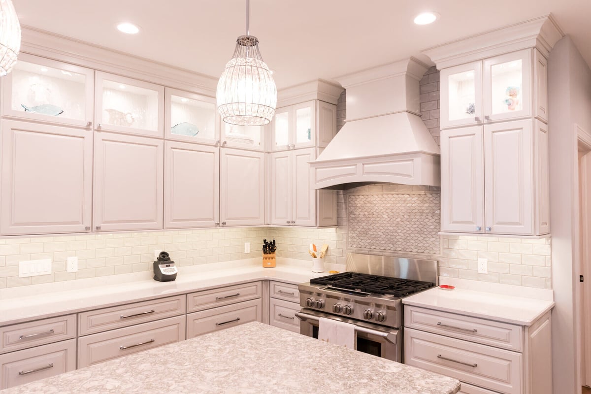 Custom kitchen renovation with illuminated upper cabinets and range hood by Ridgewood Home Construction in Grand Rapids Township