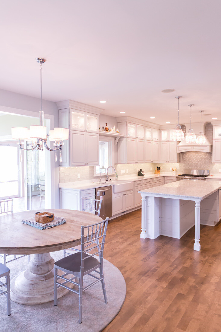 Kitchen and dining space with round table and oversized island by Ridgewood Home Construction in Grand Rapids Township