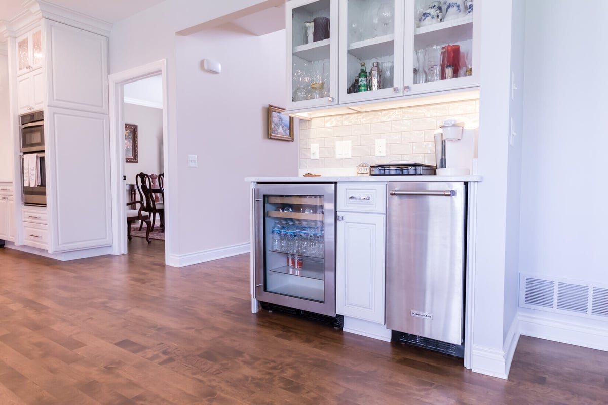 Wet bar area with beverage fridge and display cabinets in kitchen remodel by Ridgewood Home Construction in Grand Rapids Township