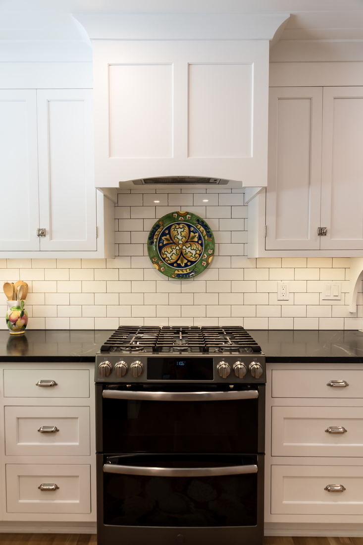 Close-up of gas range and tile backsplash in kitchen remodel by Ridgewood Home Construction in Rockford, MI