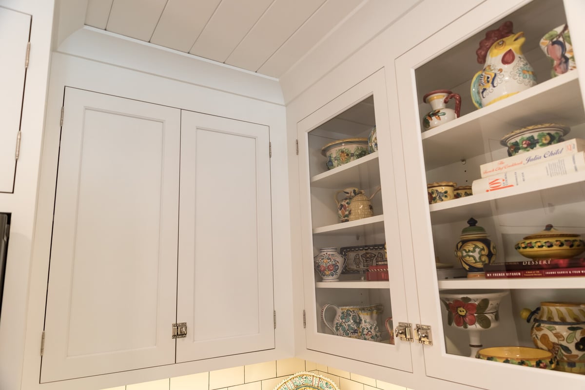 Glass cabinet doors showcasing colorful pottery in Ridgewood Home Construction kitchen remodel in Rockford, MI