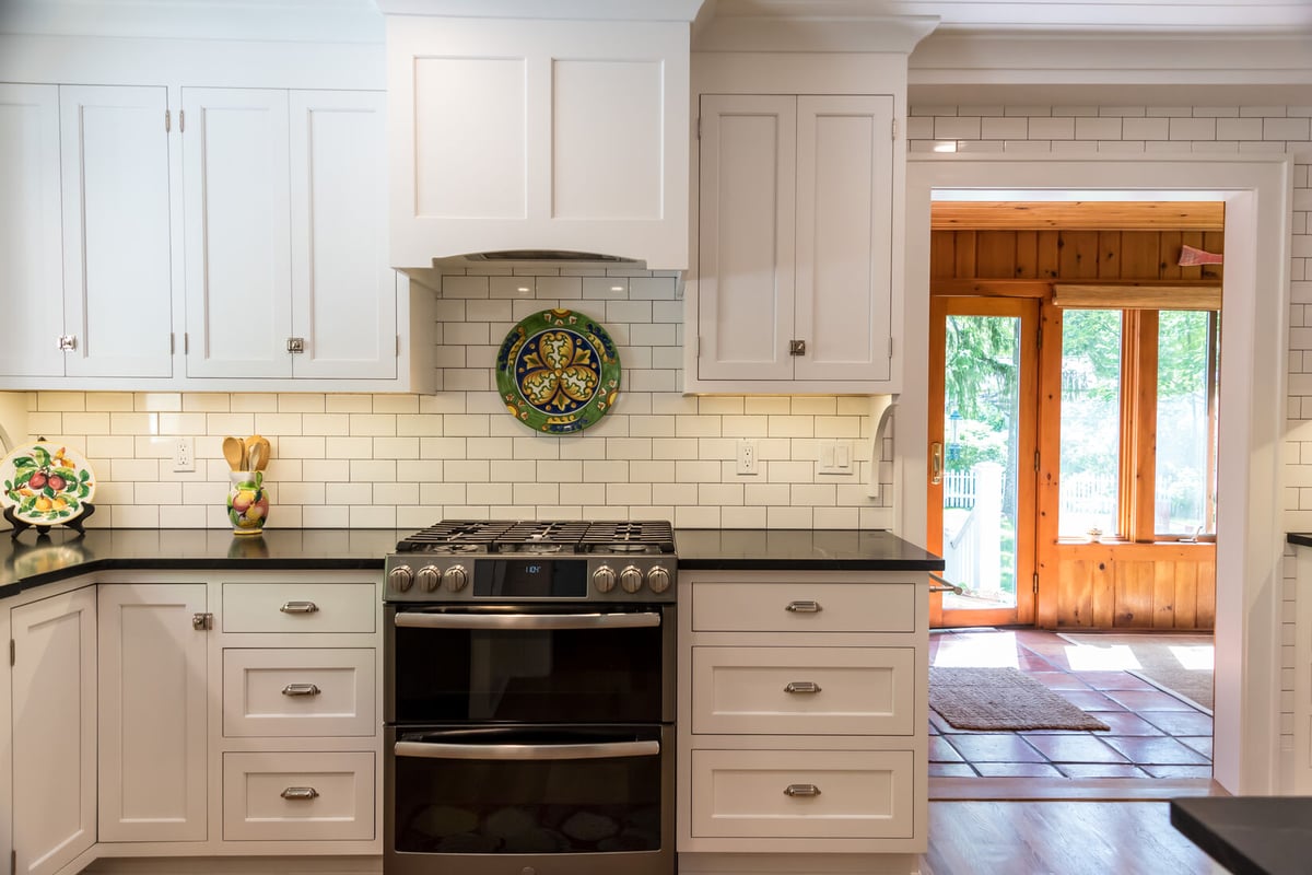 White cabinetry and gas range setup in Rockford, MI kitchen remodel by Ridgewood Home Construction