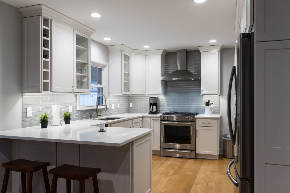 Modern kitchen remodel in Rockford, MI by Ridgewood Home Construction with gray backsplash and stainless steel appliances