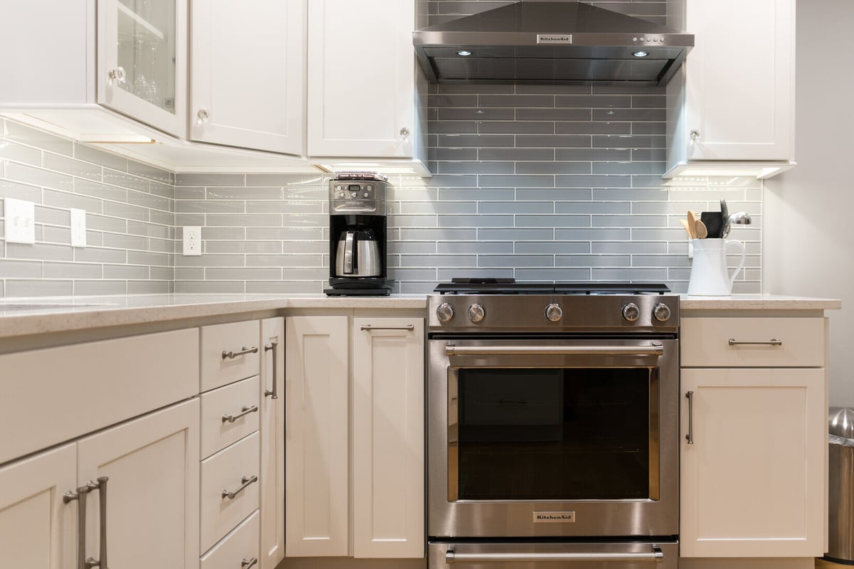 Stainless gas range with tile backsplash in Rockford, MI kitchen remodel by Ridgewood Home Construction