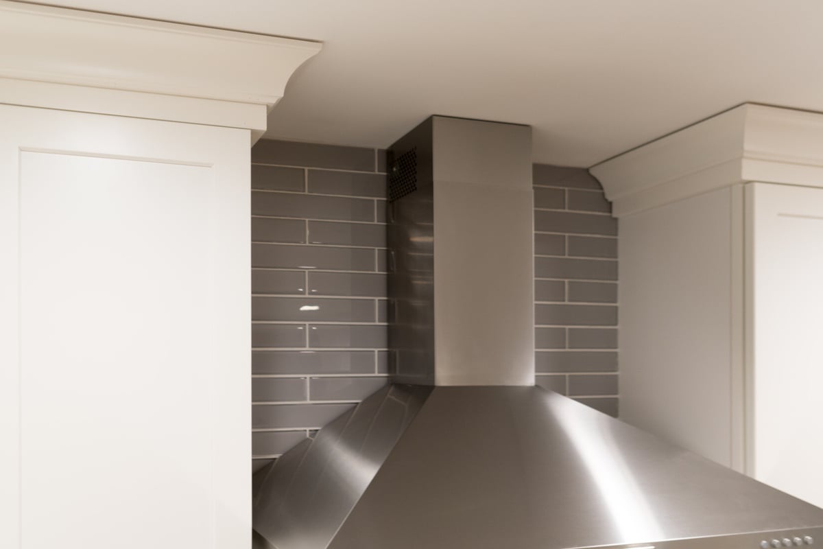 Stainless vent hood and crown molding detail in Rockford, MI kitchen by Ridgewood Home Construction
