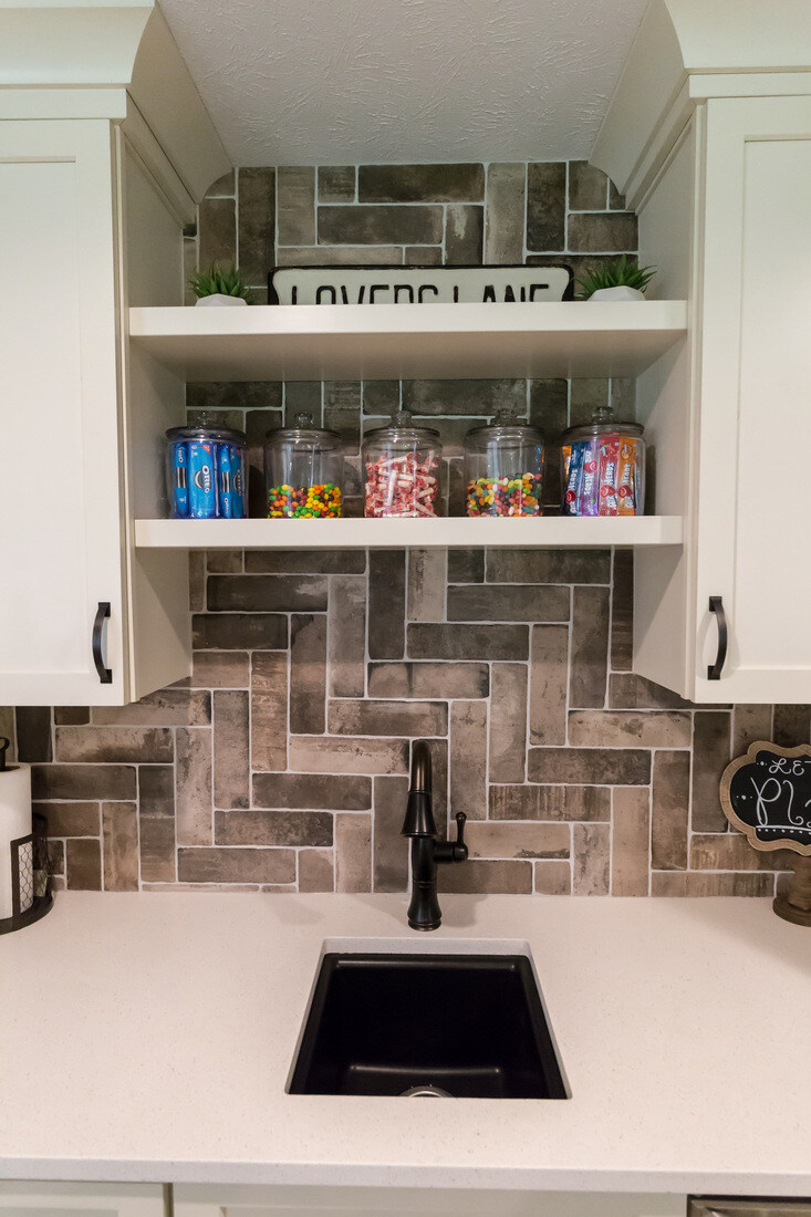 Basement kitchenette with open shelves and candy jars in Sparta, MI by Ridgewood Home Construction