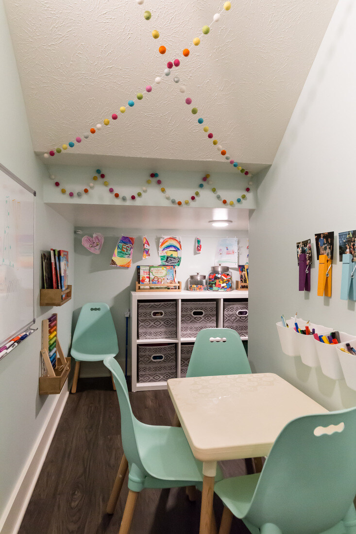 Kid-friendly craft room with pastel chairs and playful decor in Sparta, MI basement by Ridgewood Home Construction
